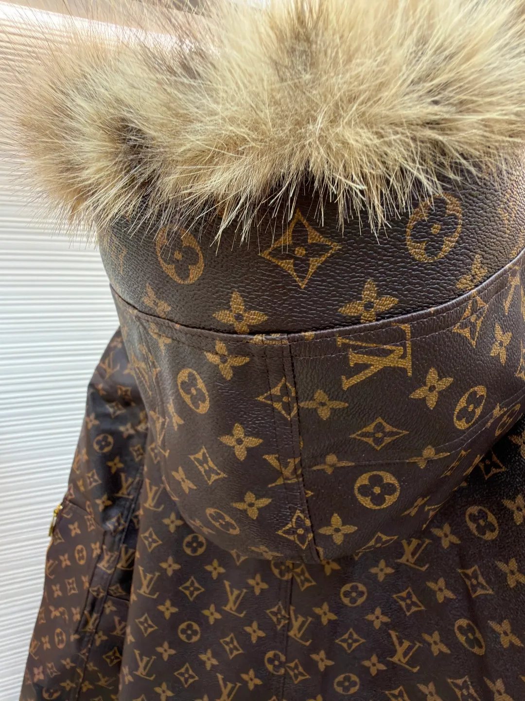 LOUIS VUITTON letter print hooded jacket ●Original version: Purchased and developed for 69999 ●Item number: 1681985-E40 ●Fabric: cotton fabric ●Technology: printing production ●Color: brown ●Version: fitted version ●Weight: about 1810 grams ●Size: 46-48-50-52 ●Description: This printed jacket is made of embossed leather fabric with a dark brown base and is fully printed with the classic Monogram pattern. The embossing process gives the logo a three-dimensional texture. The edge of the hood is spliced ​​with a natural fur collar, and the brim is equipped with an adjustable drawstring (metal rope buckle) to enhance warmth and style. The placket is double-closed with a two-way metal zipper and brass snap buttons. The zipper puller and snap button are both engraved with the brand logo, which is thick and durable. The body is designed with multiple pockets, and the pockets are edged with the same material + metal snap buttons for reinforcement. The left sleeve is equipped with a hidden adjustment tab. The interior is filled with high-fill down cotton, and the stitching adopts diamond-shaped quilting technology to prevent the filling from shifting. The seams are edged with leather of the same color, and the overall wiring is precise, taking into account warmth retention and luxurious texture. The overall wiring is straight and delicate, the fabric is comfortable and soft, and the color is consistent without color difference. It can be matched with the same style to create a fashionable look and control various occasions. Customized accessories, complete with three standards, same style for men and women!